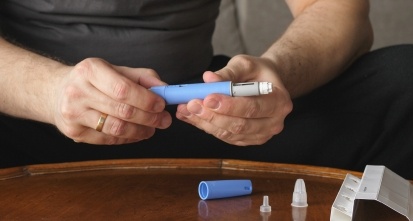 male hands holding insulin pen