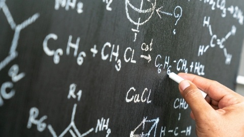 Senior chemistry professor writing on the board